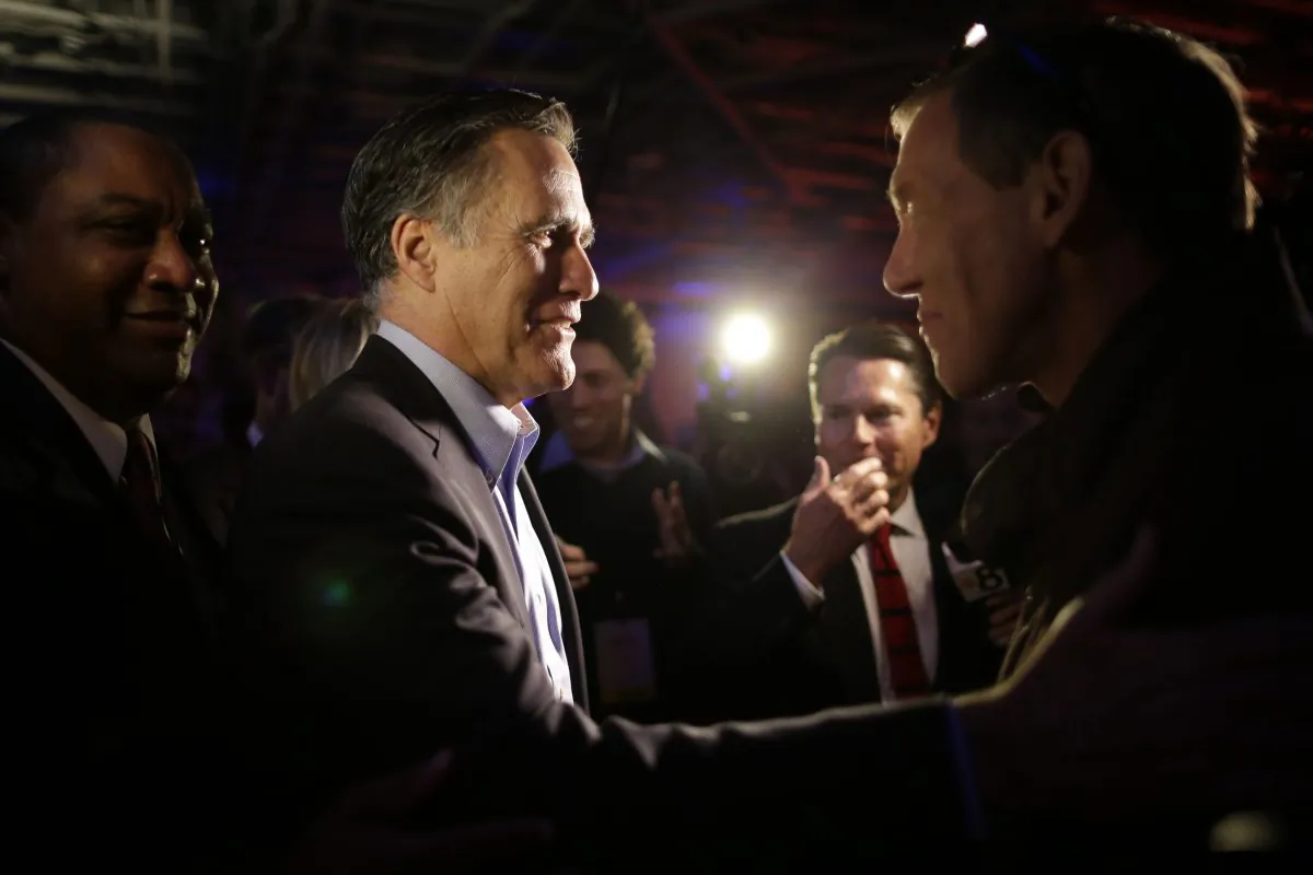Mitt Romney, the former Republican presidential nominee, left, greets people after speaking during the Republican National Committee's winter meeting aboard the USS Midway Museum Friday, Jan. 16, 2015, in San Diego. (AP Photo/Gregory Bull)