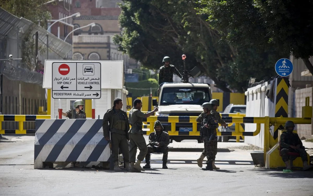 Soldiers stand guard at the gate of the French Embassy, as Yemenis protest against caricatures published in French magazine Charlie Hebdo in front of the embassy in Sanaa, Yemen, Saturday, Jan. 17, 2015. (AP Photo/Hani Mohammed)