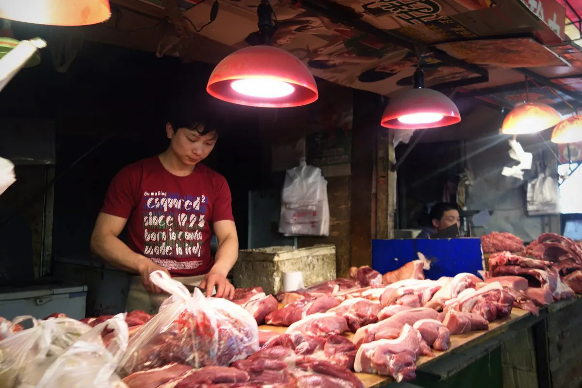 A butcher processes meat at a shop selling pork in Beijing, on June 1, 2013. Police discovered tons of tainted port products and oil products in thirty meat factories in China, arresting 110 suspects, public security announced on Jan. 11, 2015. (Wang Zhao/AFP/Getty Images)
