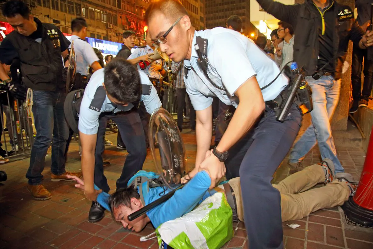 Police nab a pedestrian in Mong Kok, Hong Kong on Nov. 26, 2014. (Poon Cai Shu/Epoch Times)