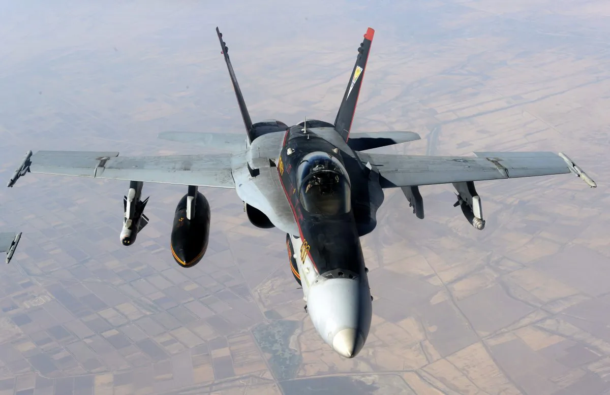 A US Navy F-18E Super Hornet supporting operations against the militant Islamic State group, leaves after receiving fuel from a KC-135 Stratotanker over Iraq, on Oct. 4, 2014. US-led airstrikes and Iranian aid have helped Iraqi troops, militiamen and Kurdish fighters take back bits around Islamic State-held territory, but recapturing it all remains far out of reach for this country held hostage. (AP Photo/US Air Force, Shawn Nickel)