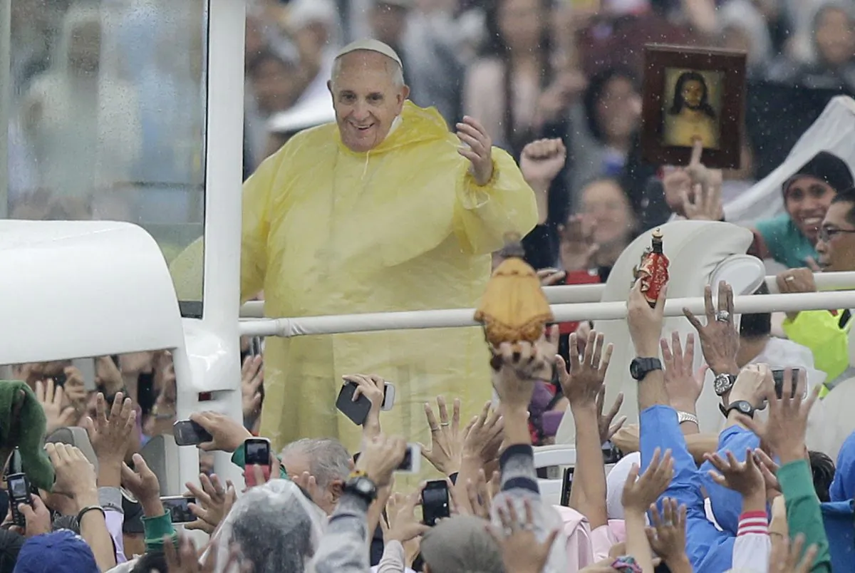Pope Francis waves the the faithful as he arrives at Rizal Park to celebrate his final Mass in Manila, Philippines, Sunday, Jan. 18, 2015. Millions filled Manila's main park and surrounding areas for Pope Francis' final Mass in the Philippines on Sunday, braving a steady rain to hear the pontiff's message of hope and consolation for the Southeast Asian country's most downtrodden and destitute. (AP Photo/Bullit Marquez)
