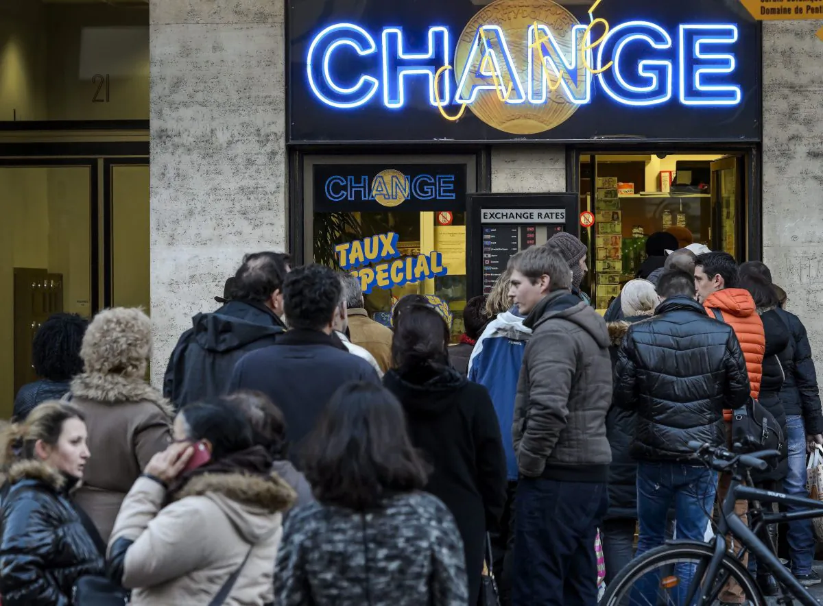 People queue at a currency exchange office in Geneva on Jan. 15, 2015. In a shock announcement on Jan. 15, Switzerland's central bank said it was ending a three-year bid to artificially hold down the value of the Swiss franc against the euro, in a move that immediately sent the safe haven currency soaring. (Fabrice Coffrini/AFP/Getty Images)