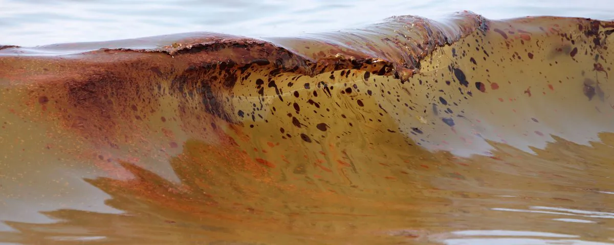 Crude oil from the Deepwater Horizon oil spill washes ashore in Orange Beach, Ala., on June 12, 2010. In arguing for adding some $13.7 billion in penalties to costs already incurred by BP following the April 2010 Deepwater Horizon explosion and Gulf oil spill, federal lawyers displayed images of fouled beaches and dead, oil-coated birds in a New Orleans courtroom on Tuesday, Jan. 20, 2015. BP points to $42 billion in costs it already has incurred in arguing for a lower penalty. (AP Photo/Dave Martin)