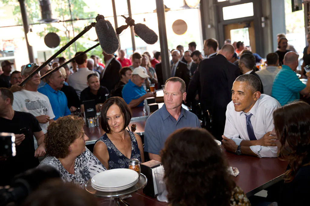 Leslie Gresham (L), Carolyn Reed, and David Johnson, all who wrote President Barack Obama (R) letters, have dinner with the President at Wazee Supper Club in Denver on July 8, 2014. Reed is a guest to watch President Barack Obama's State of the Union address on Capitol Hill Tuesday. (AP Photo/Jacquelyn Martin)