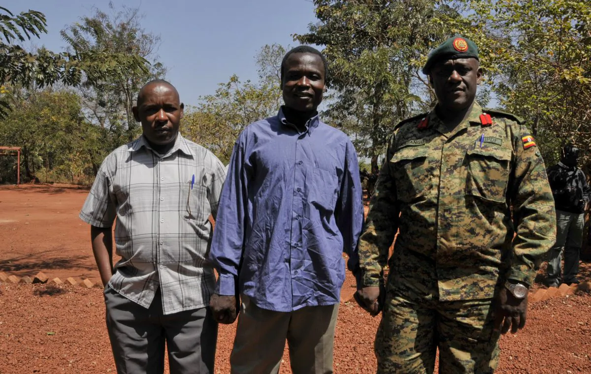 A man said by the Uganda People's Defence Force (UPDF) to be the wanted Lord's Resistance Army (LRA) commander Dominic Ongwen, center stands with Ugandan Contingent Commander to the African Union Regional Task Force Col Michael Kabango (R), and another unidentified man (L), prior to being handed over by the UPDF to the African Union Regional Task Force who later handed him over to Central African Republic authorities, in the Central African Republic, on Jan. 16, 2015. Central African Republic's Seleka rebels, who once overthrew the government, say they're entitled to a $5 million reward from the U.S. government because they say they captured and handed over the wanted international war crimes suspect Dominic Ongwen to American forces. (AP Photo/Uganda People's Defence Force, Mugisha Richard)