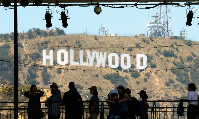Tourists are silhouetted against the distorted Hollywood sign in Los Angeles, California, on June 28, 2013. (Kevork Djansezian/Getty Images)