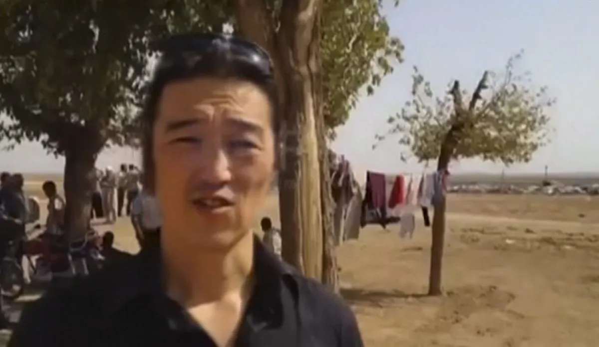 Japanese video journalist Kenji Goto reports from a Kurdish town on the outskirts of Kobani, Syria. The Islamic State group released a video on Tuesday, Jan. 20, 2015, threatening to kill two Japanese hostages, Goto, 47, and Haruna Yukawa, 42, within 72 hours unless it receives $200 million. (AP Photo/Reportr by Independent Press and Pacific Bridge Media & Consulting)
