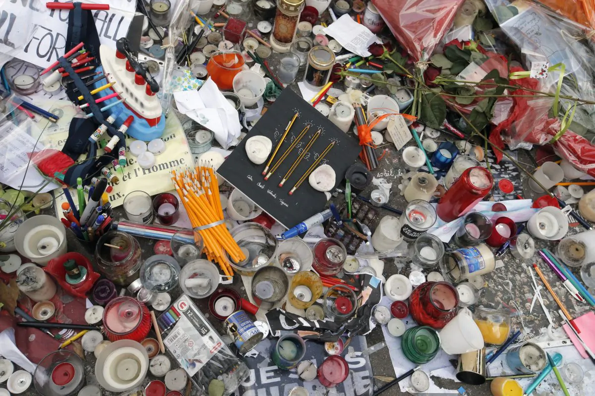 All kinds of tributes including candles and pencils are displayed on the pavement close to the Charlie Hebdo site where brothers, Said and Cherif Kouachi killed people in a terror attack at the offices of French satirical publication Charlie Hebdo, in Paris, Tuesday Jan. 20, 2015. Brothers, Said and Cherif Kouachi and their friend, Amedy Coulibaly, killed 17 people at the satirical newspaper Charlie Hebdo, a kosher grocery and elsewhere last week. (AP Photo/Francois Mori)