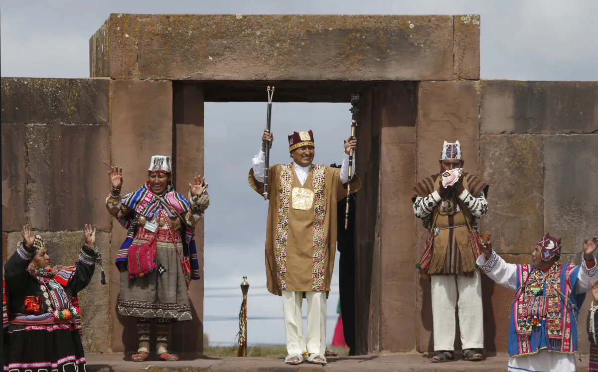 Bolivia's President Evo Morales holds his sacred staffs of power in a ceremonial swearing-in, led by Aymaran spiritual guides, at the archeological site Tiwanaku, Bolivia, Wednesday, Jan. 21, 2015. Morales is set to begin a new term Thursday, that will make him the Andean nation's longest-serving leader, riding high on a wave of unprecedented growth and stability. (AP Photo/Juan Karita)