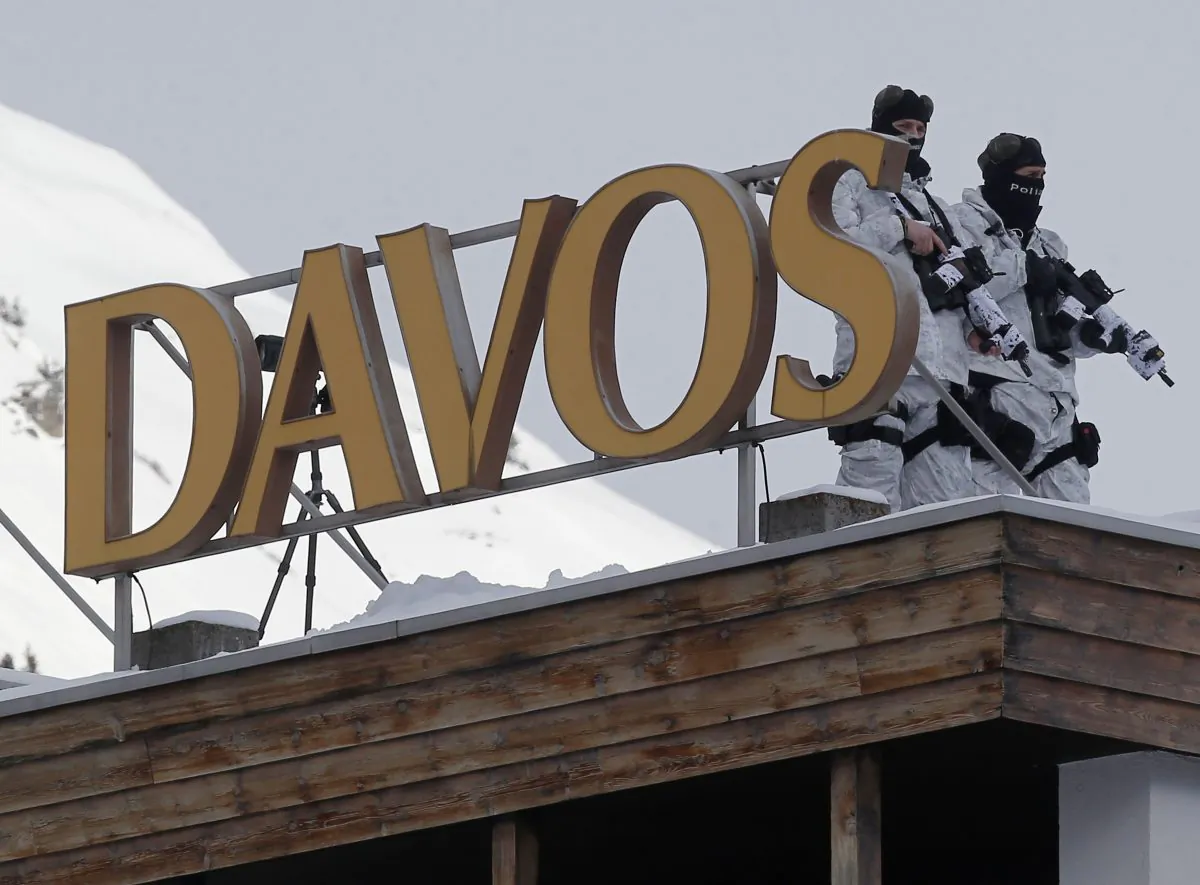 Armed Swiss police officers stand guard on the roof of a hotel, the day before the opening of the annual meeting of the World Economic Forum in Davos, Switzerland, Tuesday, Jan. 20, 2015. The world's financial and political elite will head this week to the Swiss Alps for 2015's gathering of the World Economic Forum at the Swiss ski resort of Davos. (AP Photo/Michel Euler)