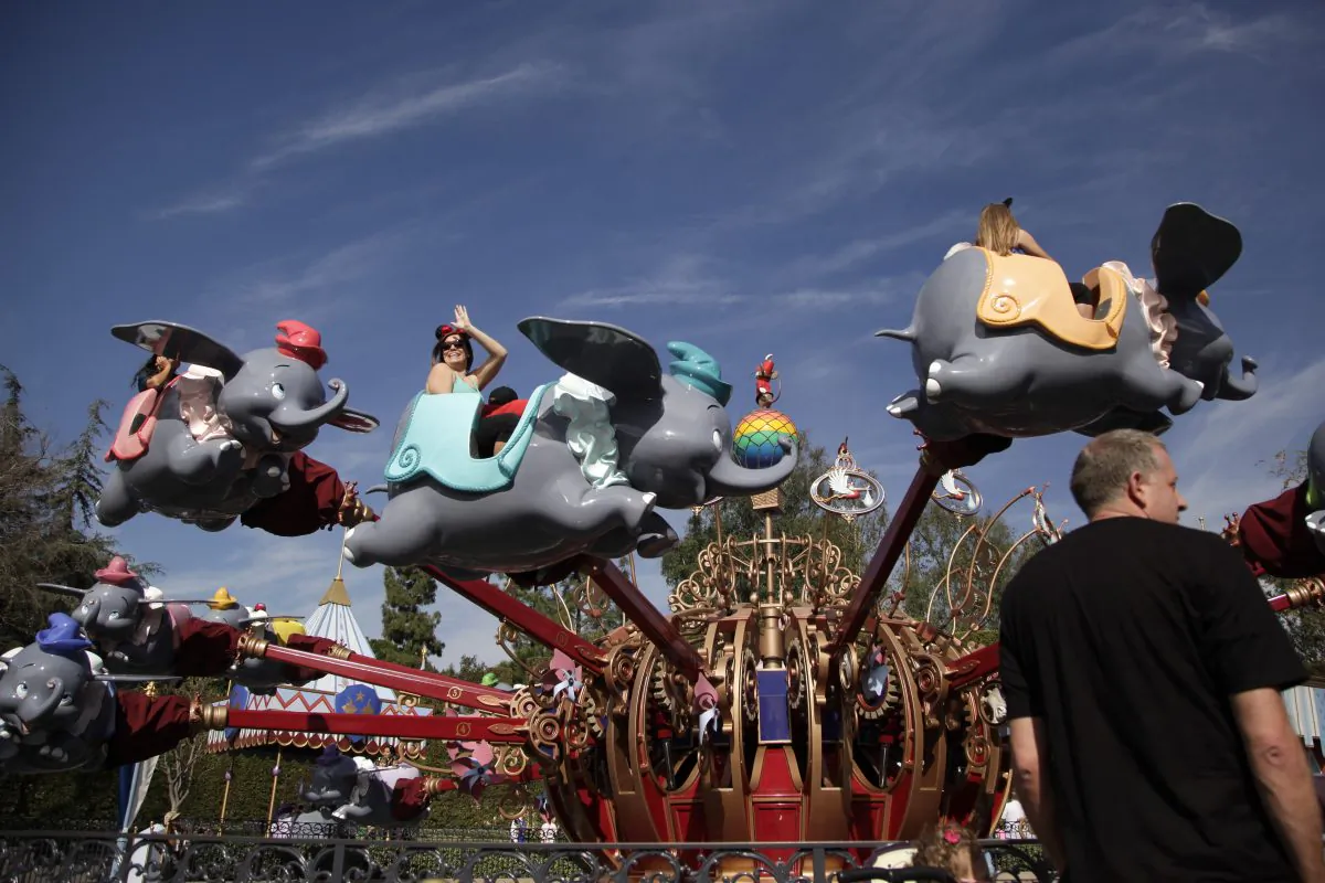 Visitors ride Dumbo the Flying Elephant at Disneyland, Thursday, Jan. 22, 2015, in Anaheim, Calif. Seventy people have been infected in a measles outbreak that led California public health officials to urge those who haven't been vaccinated against the disease, including children too young to be immunized, should avoid Disney parks where the spread originated. (AP Photo/Jae C. Hong)