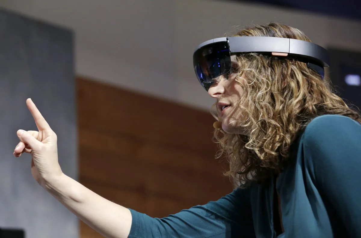 Microsoft's Lorraine Bardeen demonstrates HoloLens headset during an event at the company's headquarters in Redmond, Wash., on Jan. 21, 2015. (AP Photo/Elaine Thompson)
