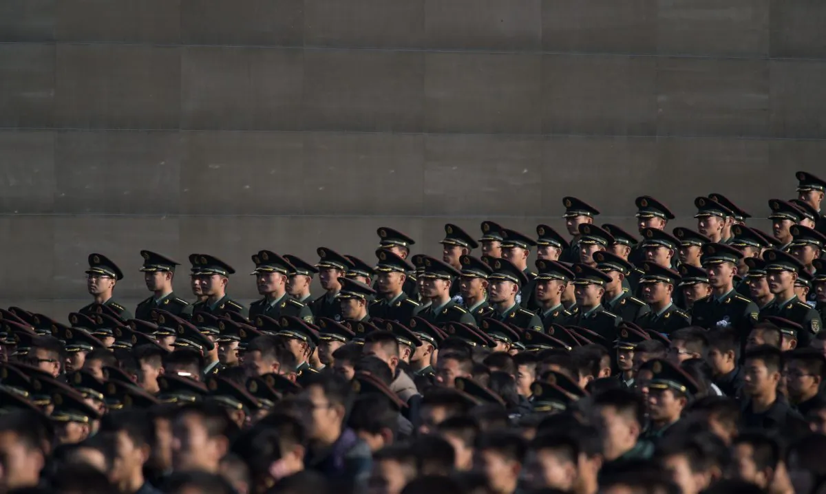 Soldiers of the People's Liberation Army (PLA) attend a memorial ceremony in Nanjing city, Jiangsu province on Dec. 13, 2014. A former office in the Chinese military recently revealed the rampant buying and selling of officer positions in the Chinese military, according to an overseas Chinese-language media. (Johannes Eisele/AFP/Getty Images)