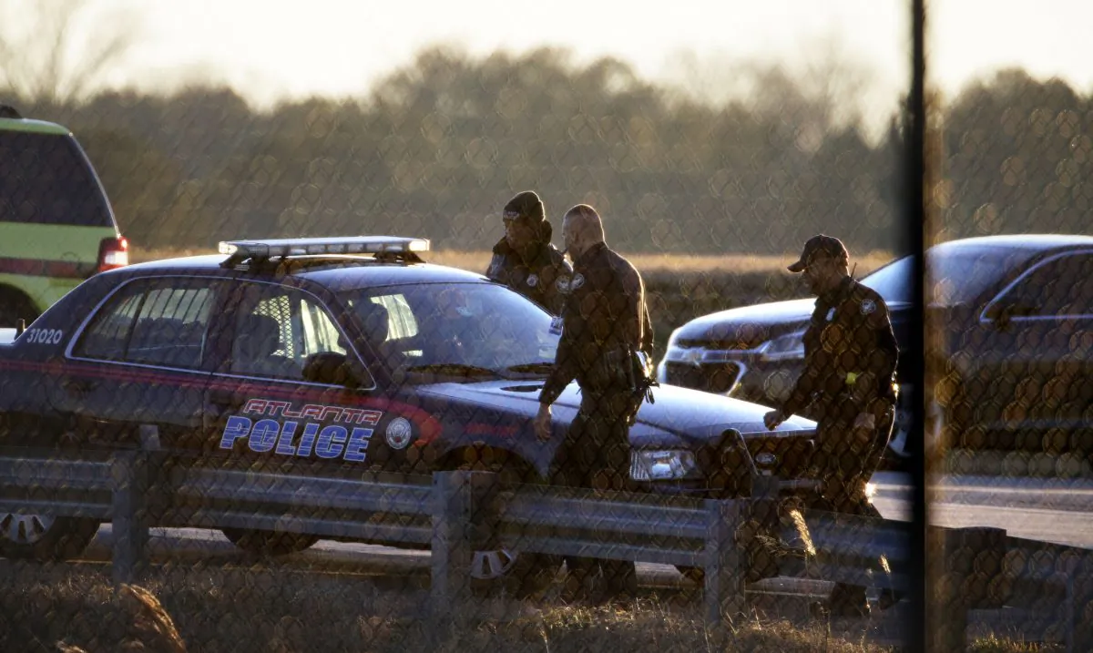 Police officers leave a fire station off the tarmac at at Hartsfield-Jackson Atlanta International Airport where two airplanes were being searched after authorities received what they described as "credible" bomb threats, Saturday, Jan. 24, 2015, in Atlanta. (AP Photo/David Goldman)