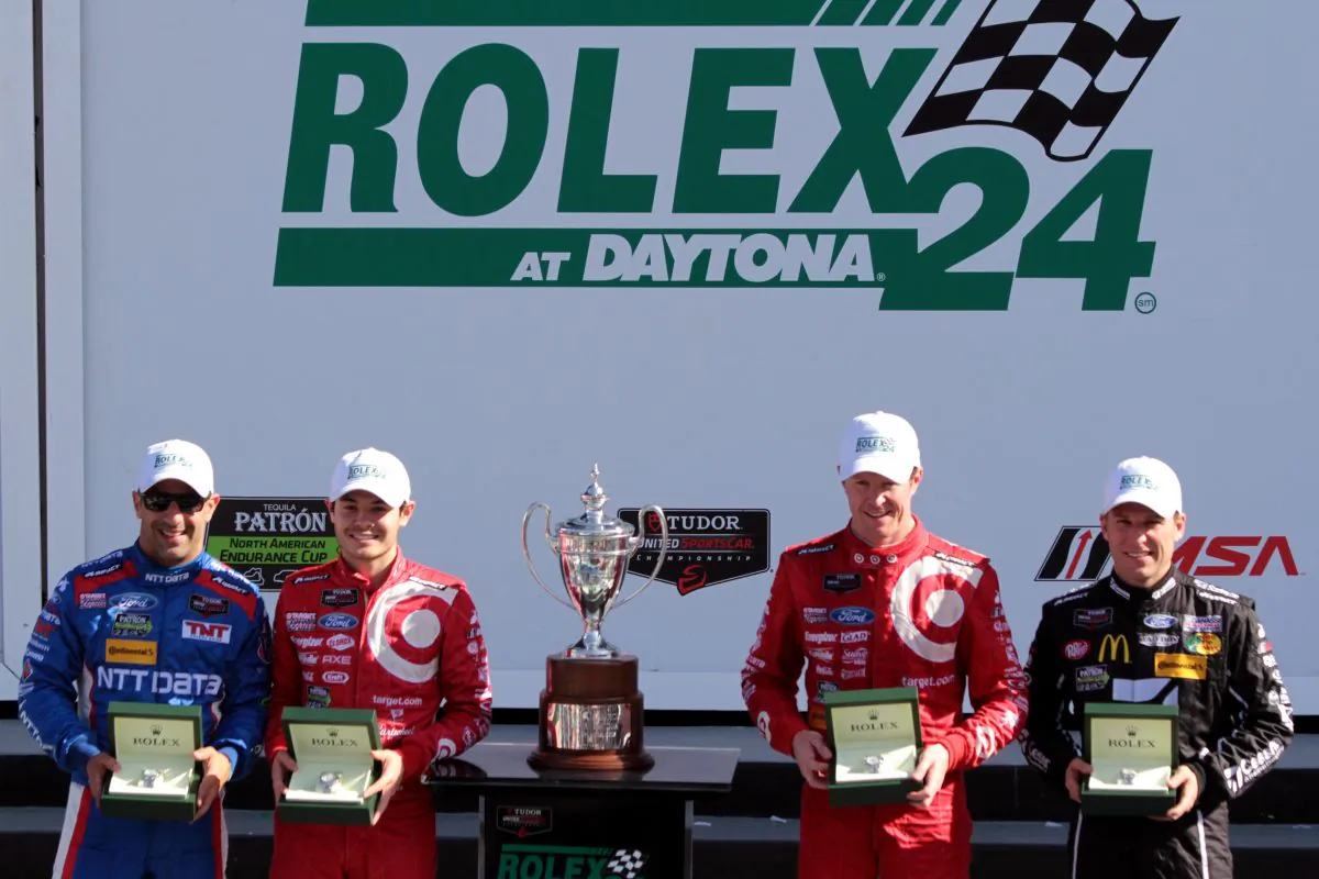 Tony Kanaan, Kyle Larson, Scott Dixon, and Jamie McMurray show off the Rolex watches and the trophy they earned by winning the Tudor United SportsCar Series Rolex 24 at Daytona. (Chris Jasurek/Epoch Times)