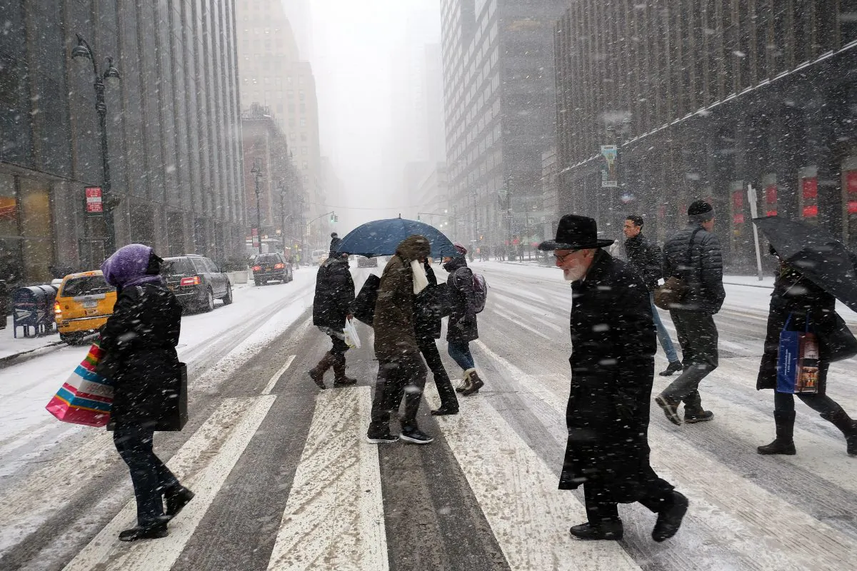 People cross a city street in a snow storm in New York on January 26, 2015. (AFP/Getty Images)