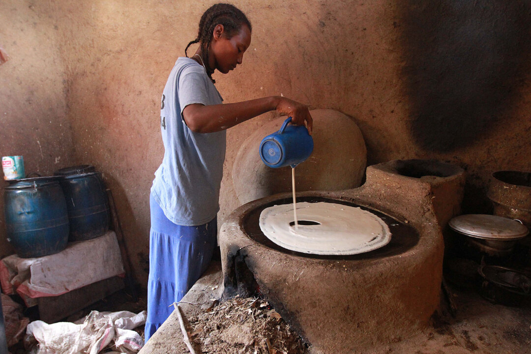 A young Ethiopian woman makes injera, a fermented bread made from the world's smallest grain. (SOLAN GEMECHU/AFP/Getty Images)