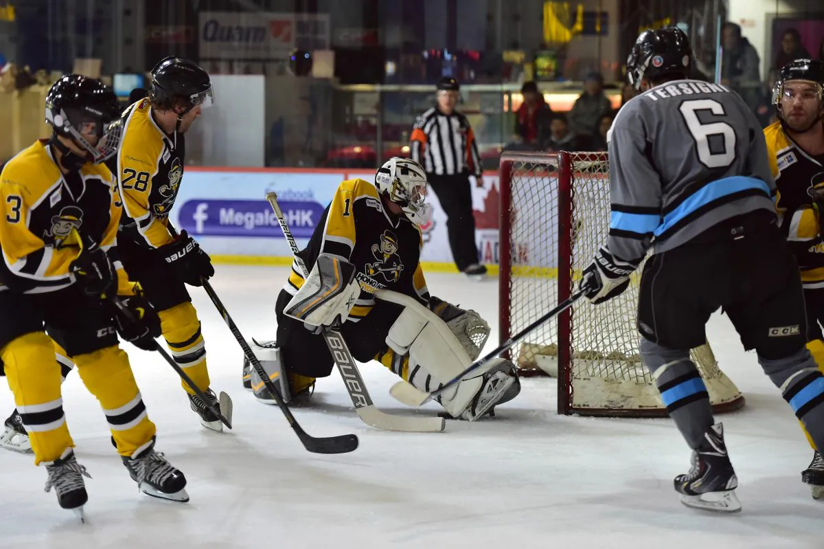 Trapped by the boot........Hong Kong Tycoons’ goalie Cody Drumm stops this attack during their CIHL match against South China Sharks at Mega Ice on Saturday Jan 24, 2015. Sharks went on to win the match in a tight 4-3 tussle and move within 2-points of the lead. (Bill Cox/Epoch Times)