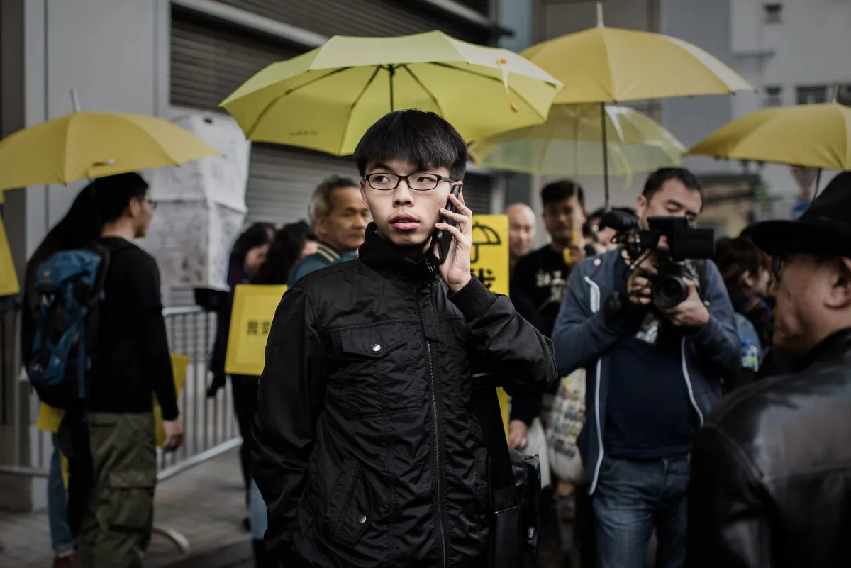 Student activist Joshua Wong talks on the phone after walking out of the Wanchai police station in Hong Kong on Jan. 16, 2015. (Philippe Lopez/AFP/Getty Images)