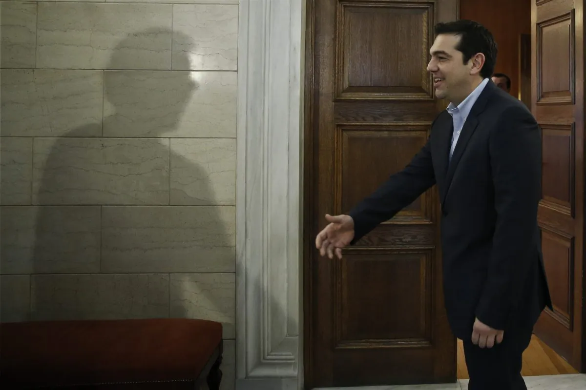 The shadow of Eurogroup chairman Jeroen Dijsselbloem is cast on a wall as Greek Prime Minister Alexis Tsipras waits to greets him during their meeting in Athens, Friday, Jan. 30, 2015. (AP Photo/Petros Giannakouris, Pool)