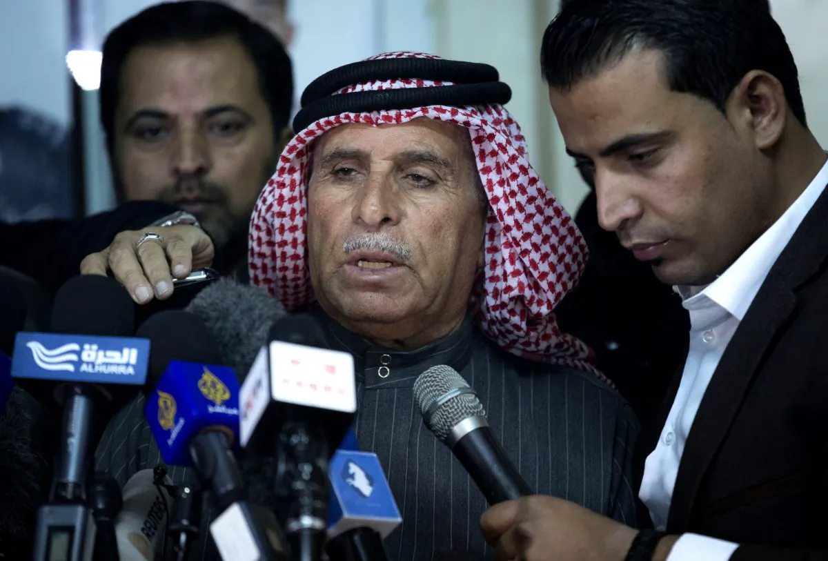 Safi al-Kaseasbeh, center, father of Jordanian pilot, Lt. Muath al-Kaseasbeh, who is held by the Islamic State group militants, reads a statement for the media urging his son's captors to have mercy on a fellow Muslim and spare his life, at the captured pilot's tribal gathering divan, in Amman, Jordan, Thursday, Jan. 29, 2015. (AP Photo/Nasser Nasser)