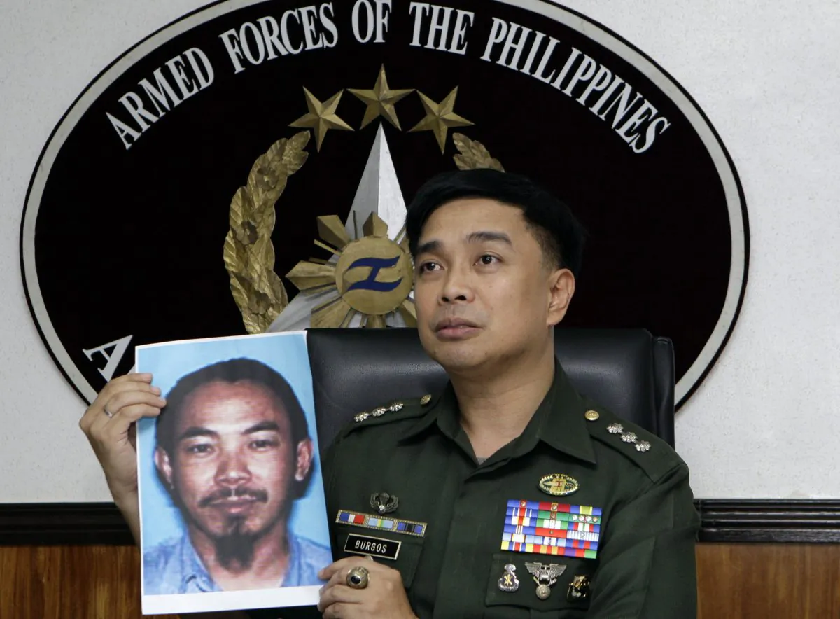 In this Feb. 2, 2012 file photo, then Armed Forces of the Philippines spokesman Col. Marcelo Burgos shows a picture of Malaysian Zulkifli bin Hir, also known as Marwan, during a press conference in suburban Quezon City, north of Manila, Philippines. (AP Photo/Pat Roque, File)