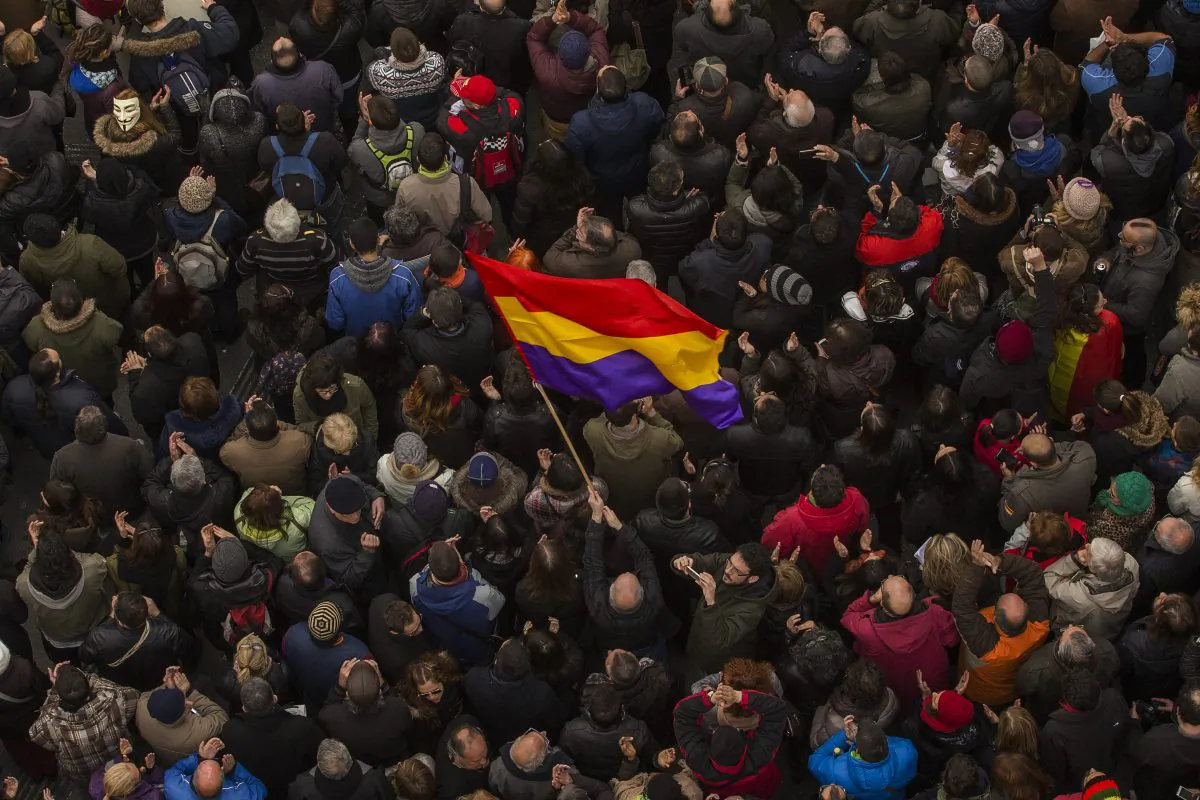 A man waves a Republican flag as people gather in the main square of Madrid during a Podemos (We Can) party march in Madrid, Spain, Saturday, Jan. 31, 2015. Tens of thousands of people  possibly more are marching through Madrid’s streets in a powerful show of strength by Spain’s fledgling radical leftist party Podemos (We Can) which hopes to emulate the electoral success of Greece’s Syriza party in elections later this year. (AP Photo/Andres Kudacki)