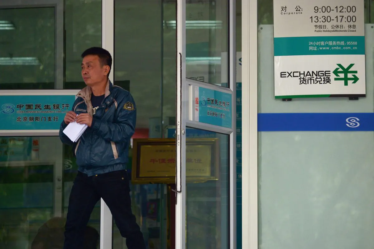 In this file photo, a man walks out of a bank in Beijing on October 31, 2013. New rules will require foreign technology companies that serve banks in Beijing to provide their source code and put backdoors in their software. (Wang Zhao/AFP/Getty Images)
