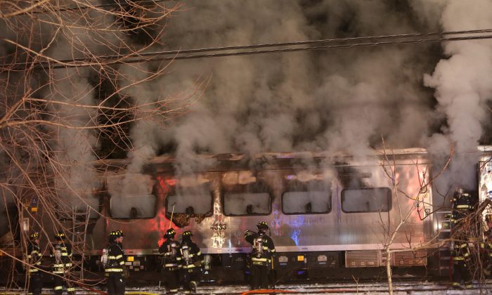 Firefighters work the scene of a collision between a Metro-North Railroad passenger train and two vehicles in Valhalla, N.Y., Tuesday, Feb. 3, 2015. (AP Photo/The Journal-News, Frank Becerra, Jr.)