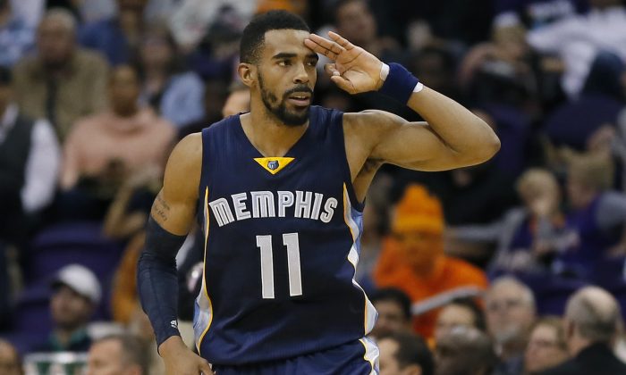 Memphis Grizzlies' Mike Conley (11) signals three after making a 3-pointer against the Phoenix Suns during the second half of an NBA basketball game, Monday, Feb. 2, 2015, in Phoenix. The Grizzlies won 102-101. (AP Photo/Matt York)