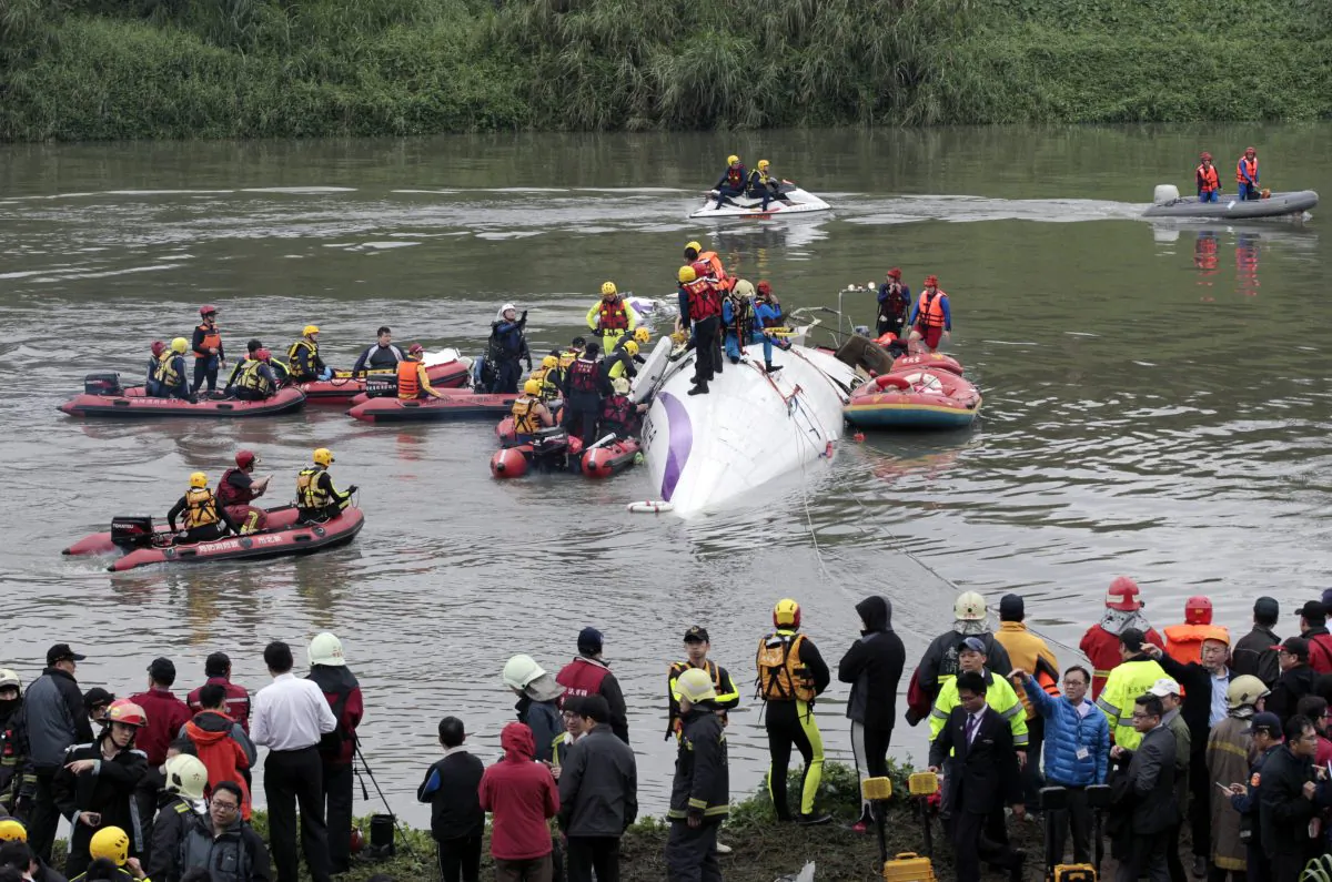 Emergency personnel try to extract passengers from a commercial plane after it crashed in Taipei, Taiwan, Wednesday, Feb. 4, 2015. (AP/Wally Santana) 