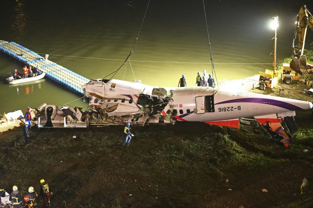 The mangled fuselage of a TransAsia Airways commercial plane is dragged to the river bank after it crashed in Taipei, Taiwan. The Taiwanese commercial flight with 58 people aboard clipped a bridge shortly after takeoff and crashed into a river in the island's capital of Taipei on Wednesday morning, Feb. 4, 2015. (AP Photo)