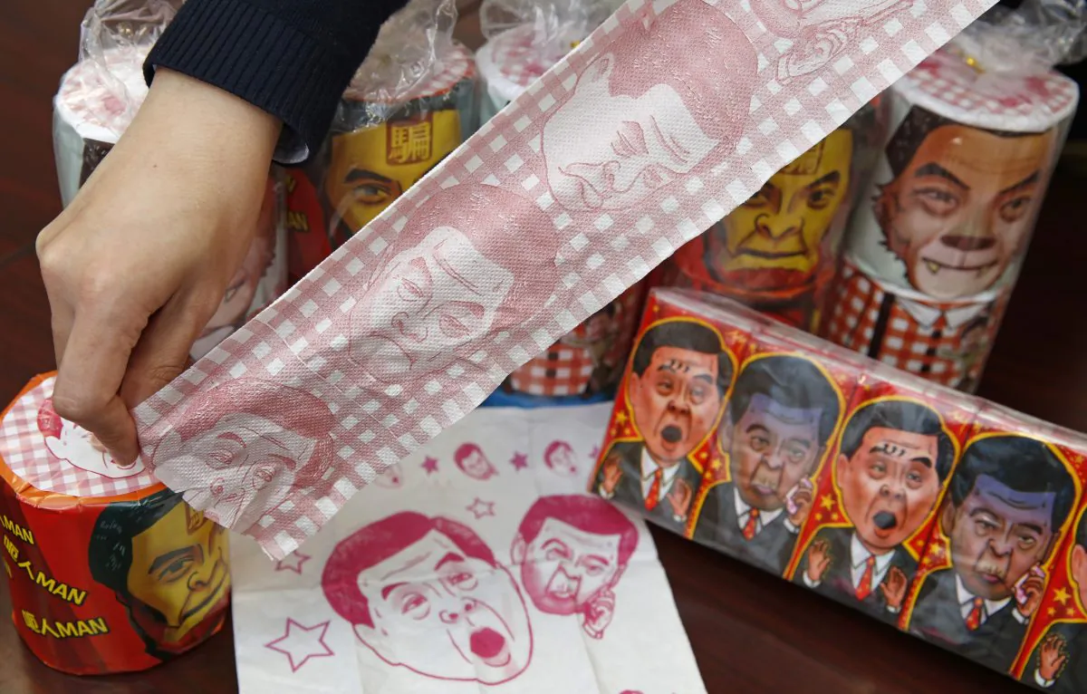 Hong Kong Democratic Party Vice Chairman Lo Kin-hei shows off rolls of toilet paper and packages of tissue paper printed with images of pro-Beijing Hong Kong Chief Executive Leung Chun-ying at his office in Hong Kong Saturday, Feb. 7, 2015. (AP Photo/Kin Cheung)