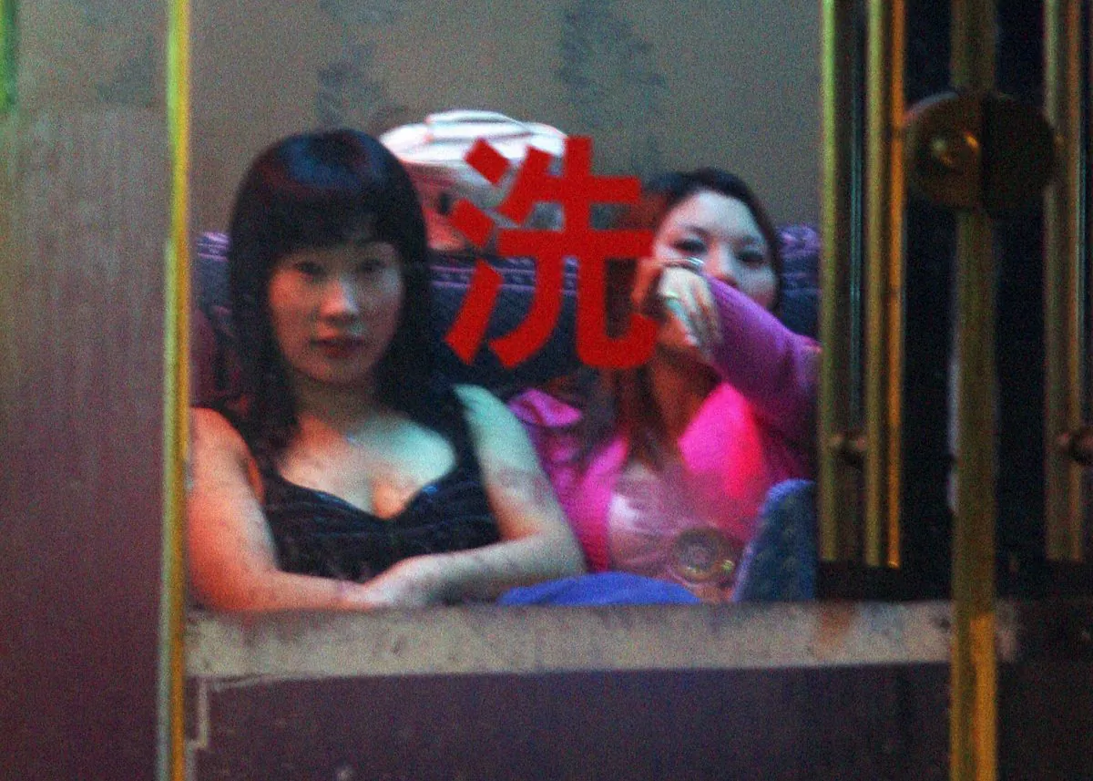 Chinese prostitutes wait for customers at a neighborhood brothel in Shanghai, 29 November 2006. Officials in the Chinese Communist Party and government were involved in over 700,000 extramarital affairs in 2014, according to a report by the Hong Kong magazine Chengming. (Mark Ralston/AFP/Getty Images)