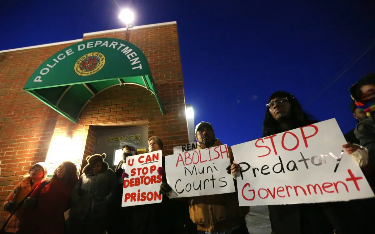 Protesters block the entrance to the Pine Lawn Police Department on Thursday, Feb. 5, 2015, in Pine Lawn, Mo.  They were demonstrating against the municipal court's practice of collecting fines from indigent defendants. (AP Photo/St. Louis Post-Dispatch, Chris Lee) 