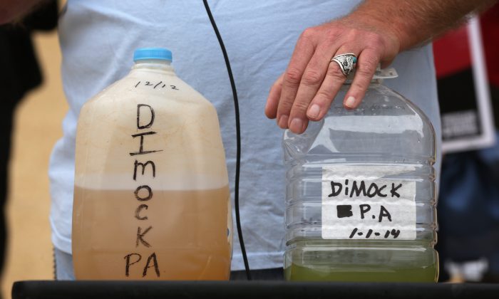  Ray Kemble of Dimock, Pa., show water samples outside EPA's Headquarters in Washington, D.C., during a rally on fracking-related water investigations, on Oct. 10, 2014 (Alex Wong/Getty Images)