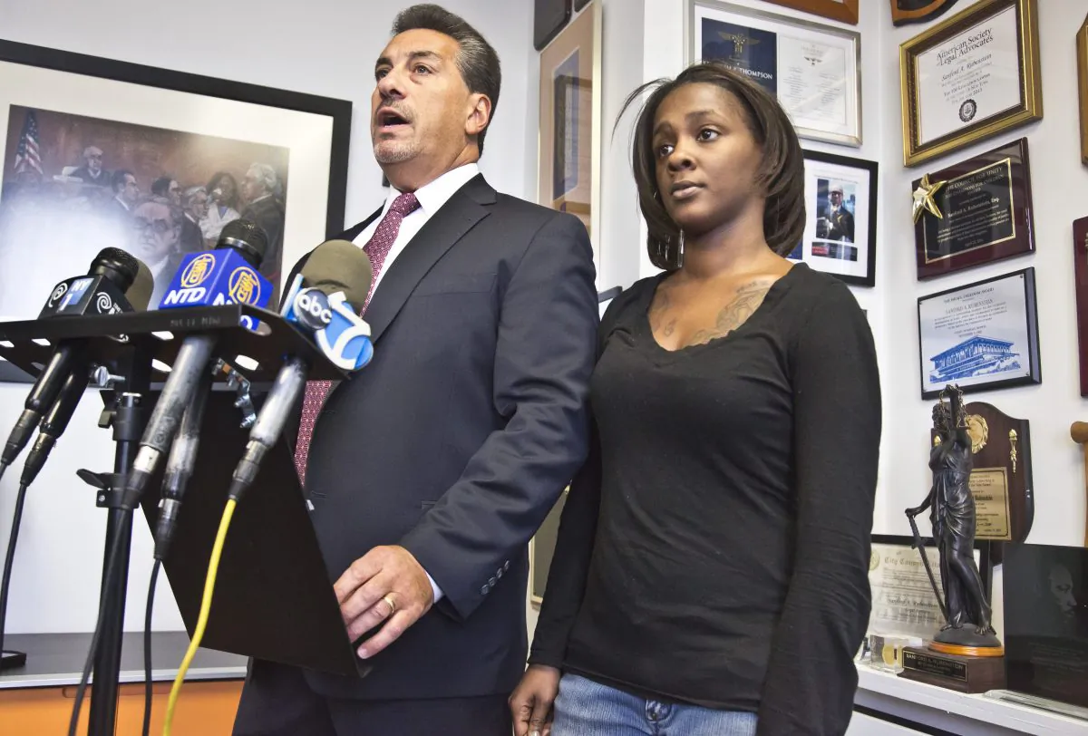 Attorney Scott Rynecki, left, and Kimberly Ballinger, the domestic partner of Akai Gurley and the mother of his toddler daughter, at a press conference on Thursday, Jan. 29, 2015, in New York City. The NYPD officer who shot and killed Gurley inside a Brooklyn housing project stairway has been indicted on charges of manslaughter. (AP Photo/Bebeto Matthews)