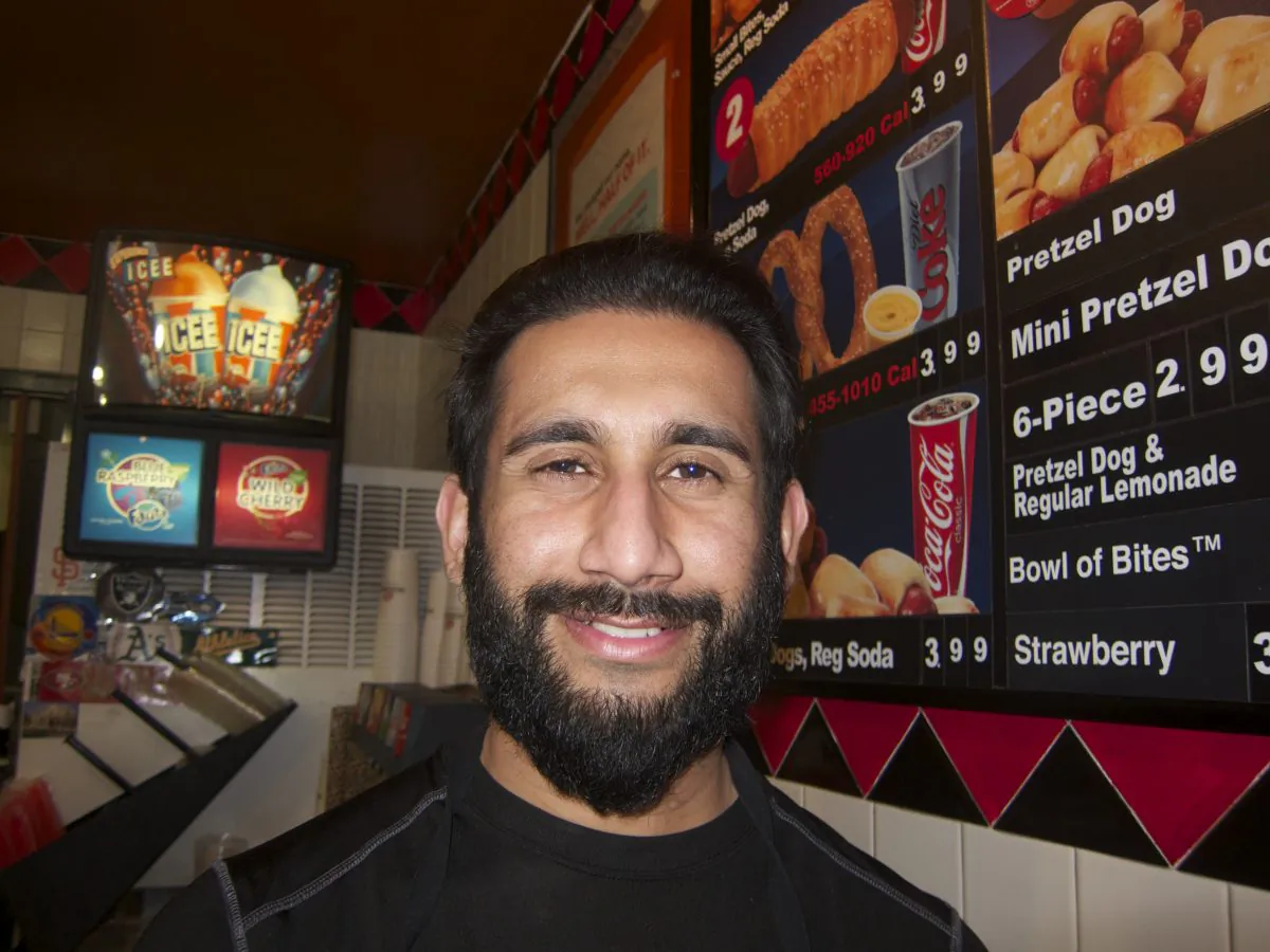 Osman Khan, of Hayward, commutes over forty miles to his cashier job at Pretzelmaker because jobs are hard to come by in his city. (Chun Lee/Epoch Times)