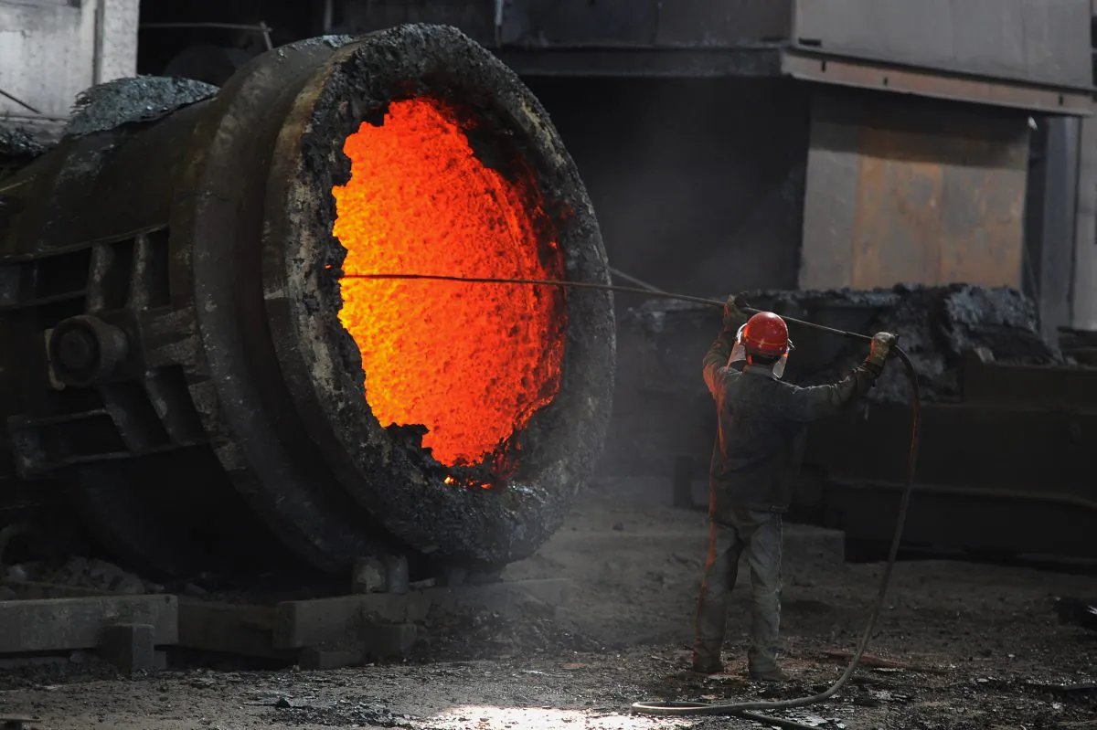 A Chinese worker stokes a burning cauldron at a steel mill in Hefei, Anhui, China, on June 25, 2011. (STR/AFP/Getty Images)