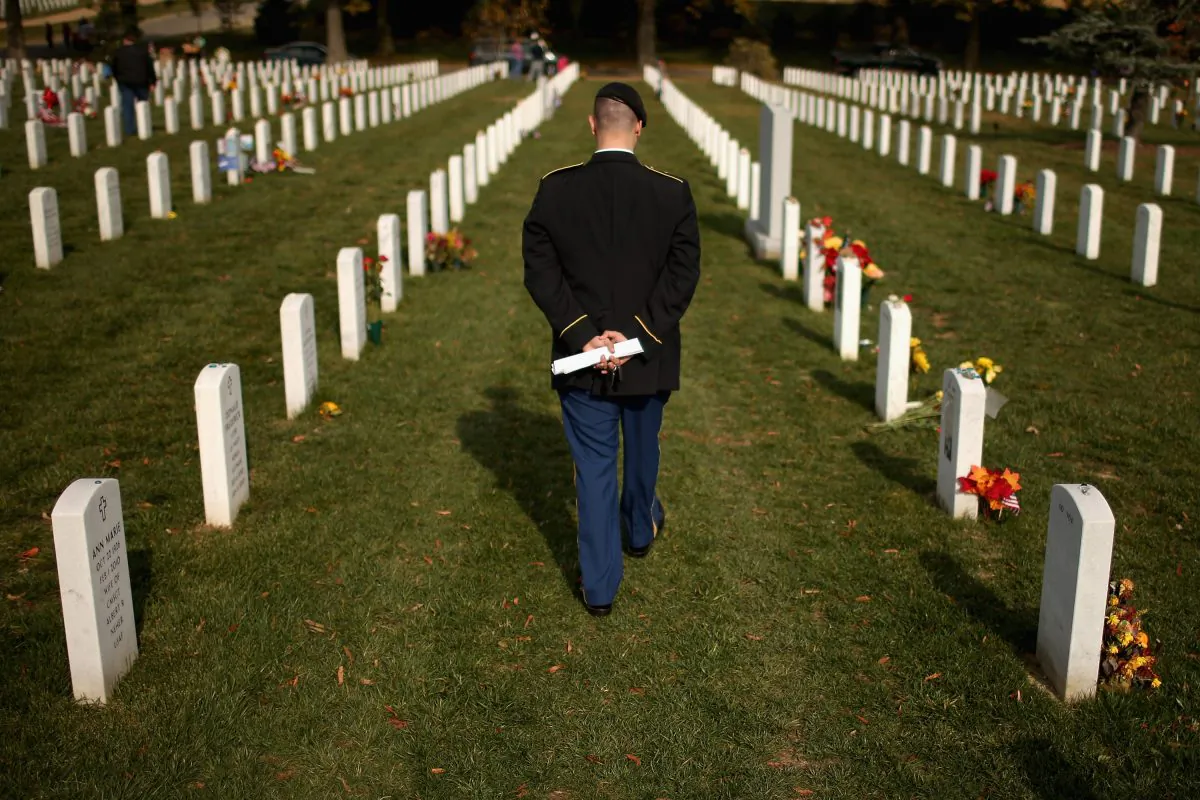 Army Staff Sgt. Luke Parrott walks through a rows of headstones at Arlington National Cemetery in Arlington, Va., on Nov. 12, 2012, the day after Veterans Day. (Chip Somodevilla/Getty Images)