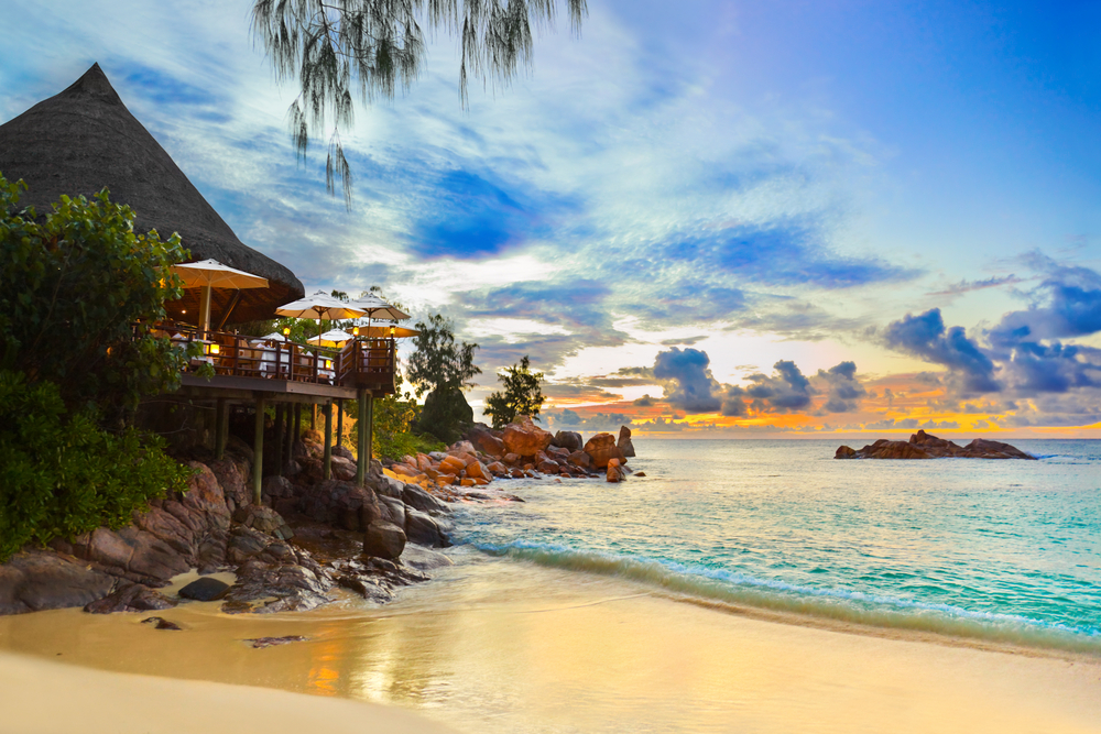 Cafe on tropical beach at sunset in Seychelles via Shutterstock*