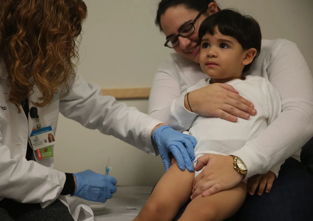 Yasunary Garrido holds her son, Samuel Espinoza, 2, as he receives a flu vaccination in the leg from pediatrician Amanda Porro, M.D., during a visit to the Miami Children's Hospital on Jan. 7, 2015. (Joe Raedle/Getty Images)