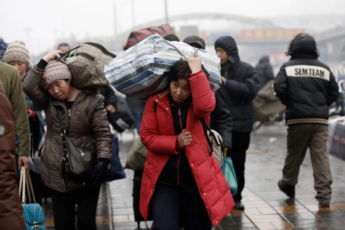 Migrant workers arrive at the Beijing Railway Station with their luggage on January 31, 2013 in Beijing, China. The Ministry of Public Security, an agency with the State Council, announced a plan to scrap the “temporary” residence permit in China. (Lintao Zhang/Getty Images)