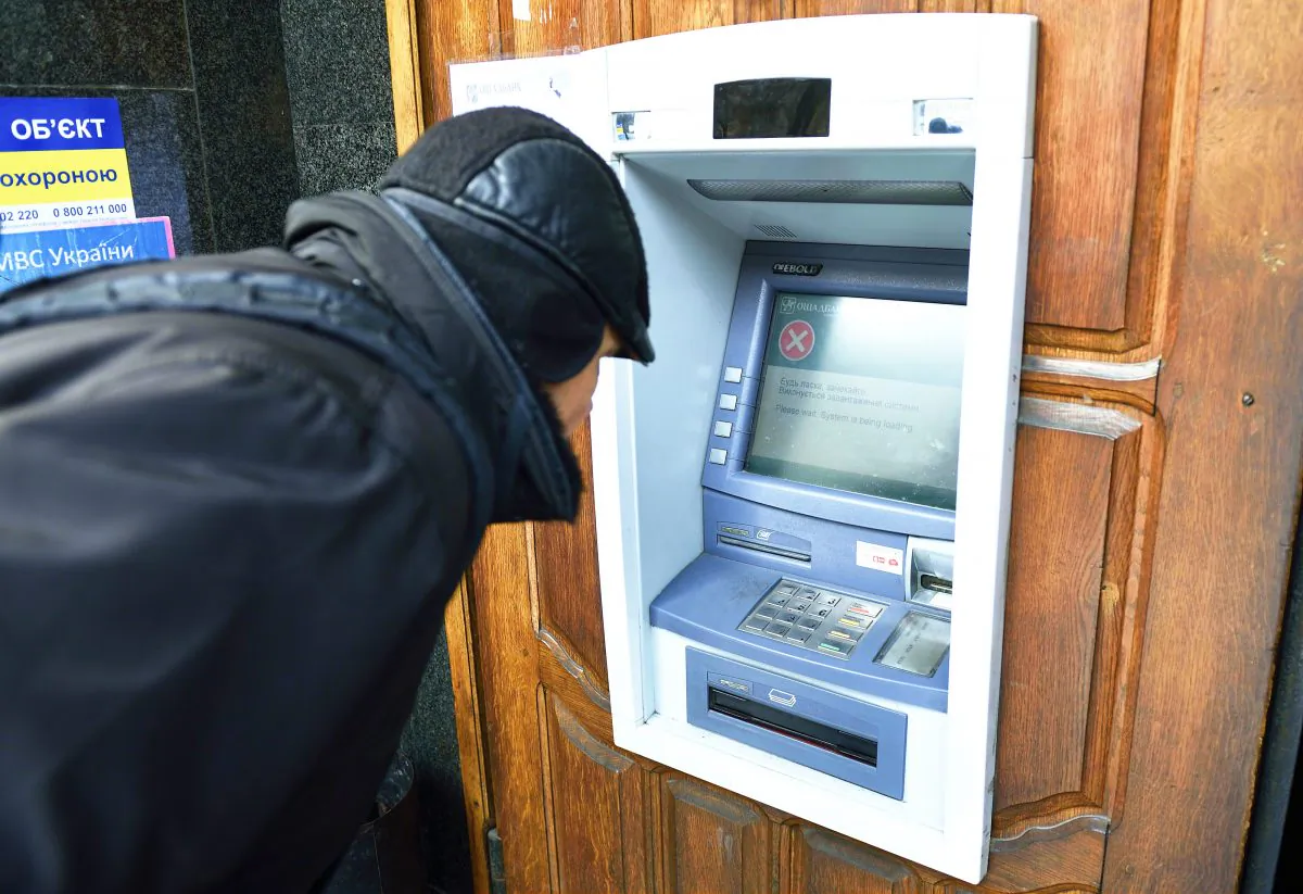 A man stands in front an ATM machine which is out of order, on November 26, 2014 in the eastern Ukrainian city of Donetsk. (ERIC FEFERBERG/AFP/Getty Images)