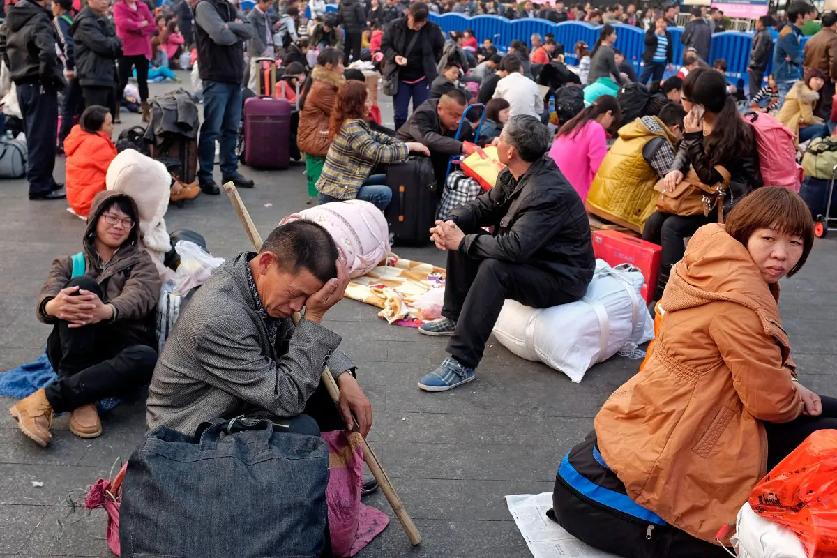 Travelers wait for their trains by passing time outside the Guangzhou train station on January 28, 2014 in Guangzhou, China. (Theodore Kaye/Getty Images)