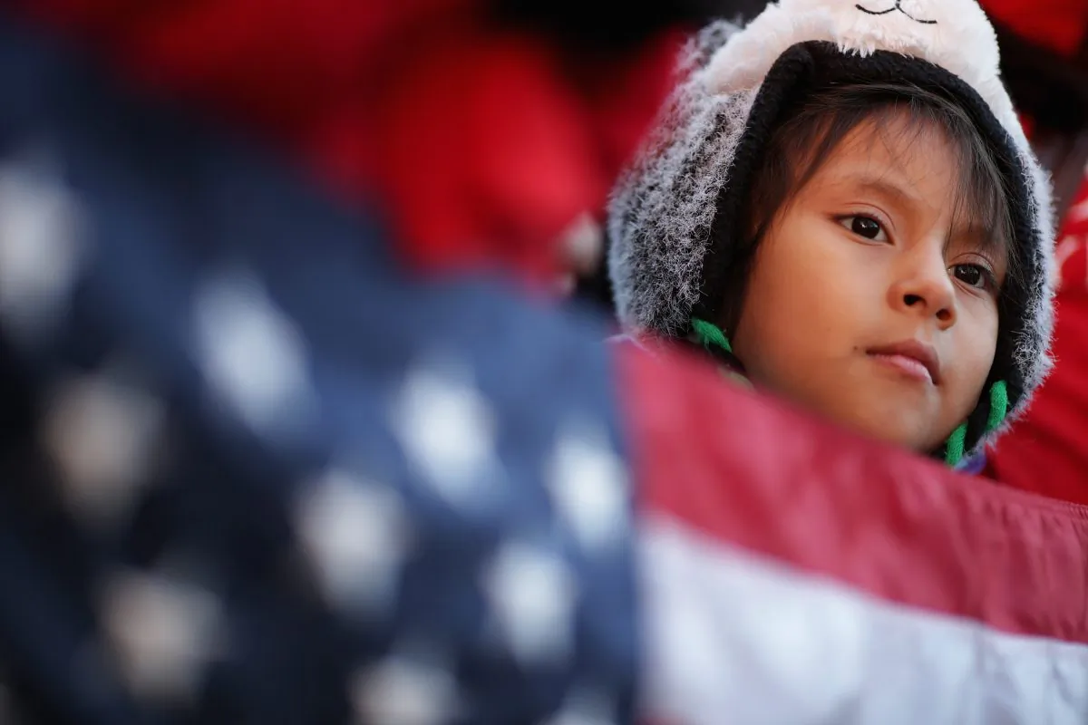 A little girl holds the American flag during a rally in support of President Barack Obama’s executive action on immigration policy in Washington on Nov. 21, 2014. (Chip Somodevilla/Getty Images)