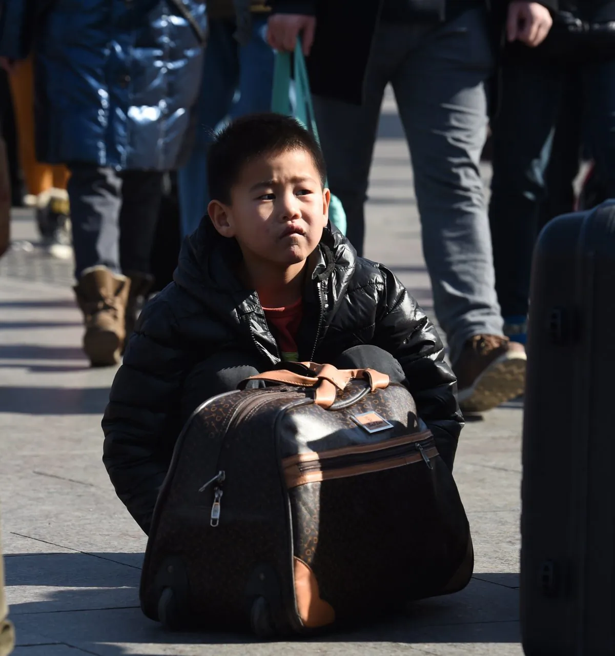 A boy waits with his parents outside Beijing railway station on Feb. 17, 2015. Hundreds of millions of Chinese are returning to their hometowns to celebrate the lunar new year, which begins Feb. 19, with families in what is the world's largest annual migration. (Greg Baker/AFP/Getty Images)