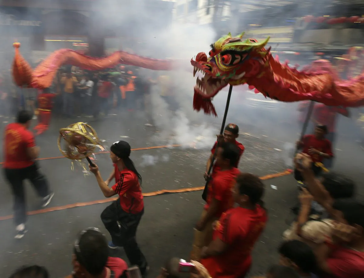 Dragon dancers perform in front of a supermarket at Manila's Chinatown district of Binondo to celebrate the Chinese New Year Thursday, Feb. 19, 2015 in Manila, Philippines. This year marks the "Year of the Sheep" in the Chinese Lunar calendar. (AP Photo/Bullit Marquez)