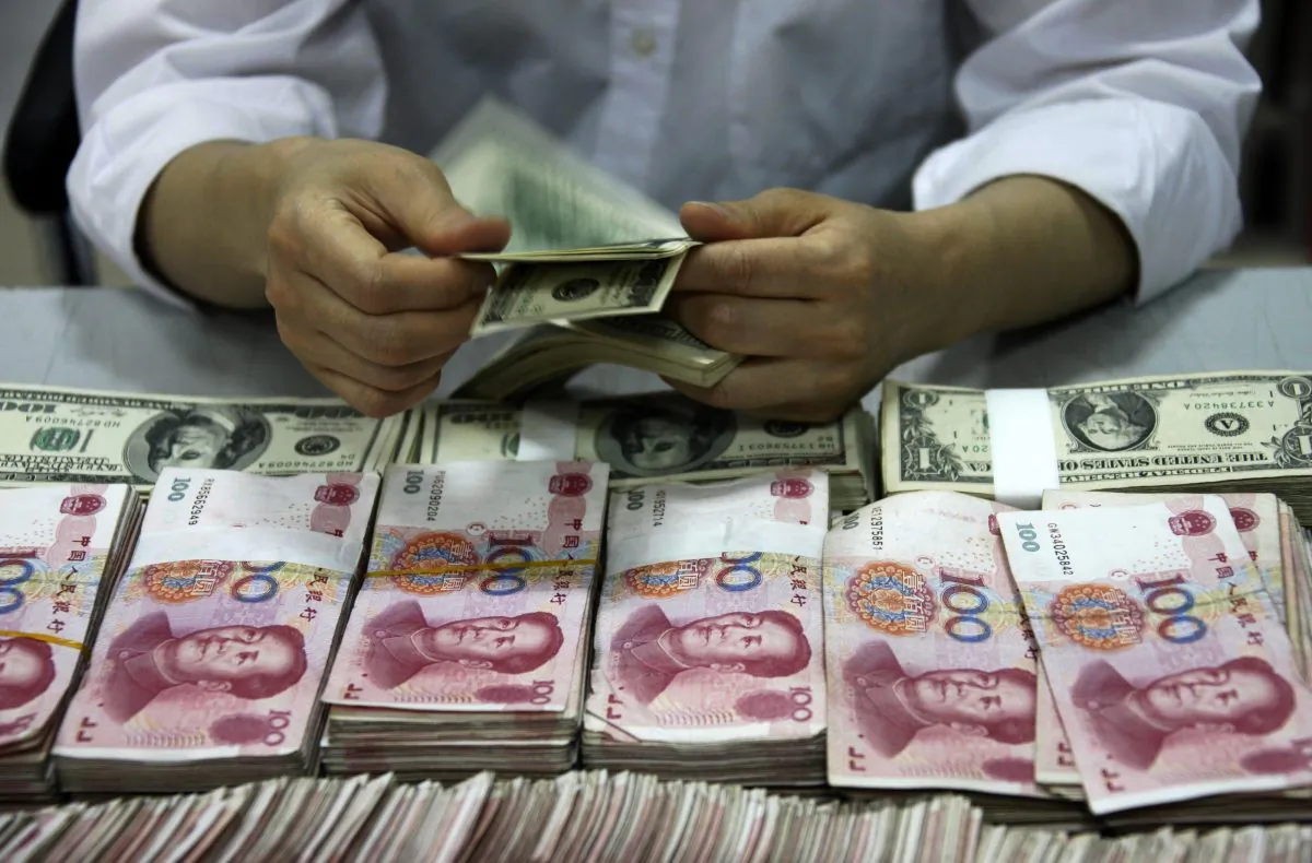 U.S. dollar notes are counted next to stacks of Chinese 100 yuan bank notes at a bank in Huaibei, Anhui Province, China. (STR/AFP/Getty Images)